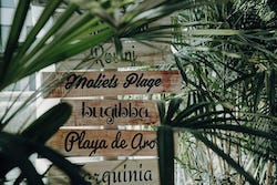 Holzschild mit verschiedenen Urlaubsdestinationen